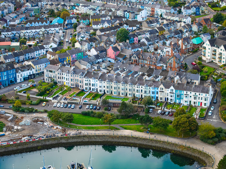 Aerial view of Bangor Harbour and Town featuring colourful terraced houses a marina with boats and green waterfront spaces in Bangor Northern Ireland United Kingdom.