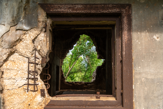 View of the weathered concrete walls and jagged opening of the historic North Field Base revealing lush green foliage in Northern Tinian Tinian Northern Mariana Islands. View of the weathered concrete walls and jagged opening of the historic North Field Base revealing lush green foliage in Northern Tinian Tinian Northern Mariana Islands.