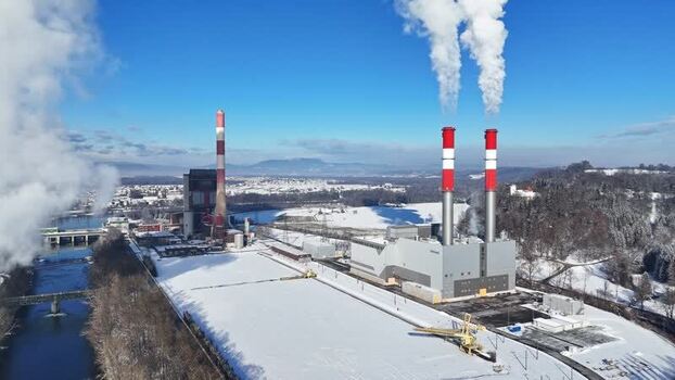 Aerial view of a power plant with smoking chimneys in winter Austria.