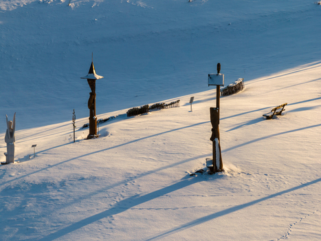 Aerial view of Hill of Angels with wooden sculptures casting long shadows over the pristine snow covered landscape in Traku rajonas Vilniaus apskritis Lithuania. Aerial view of Hill of Angels with wooden sculptures casting long shadows over the pristine snow covered landscape in Traku rajonas Vilniaus apskritis Lithuania.