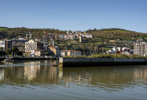 View of the urban landscape with buildings on a hillside and the riverfront in Greater Bilbao Basque Country Spain. View of the urban landscape with buildings on a hillside and the riverfront in Greater Bilbao Basque Country Spain.
