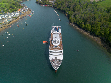 Fowey United Kingdom 01 May 2026 Aerial view of a large cruise ship anchored in the Fowey river near the historic town of Fowey surrounded by lush green hills and small boats. Fowey United Kingdom 01 May 2026 Aerial view of a large cruise ship anchored in the Fowey river near the historic town of Fowey surrounded by lush green hills and small boats.
