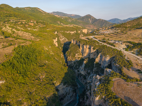 Aerial view of Osumi Canyon showcasing its deep limestone cliffs winding river lush green vegetation and rugged landscape in Dhores Berat County Albania.