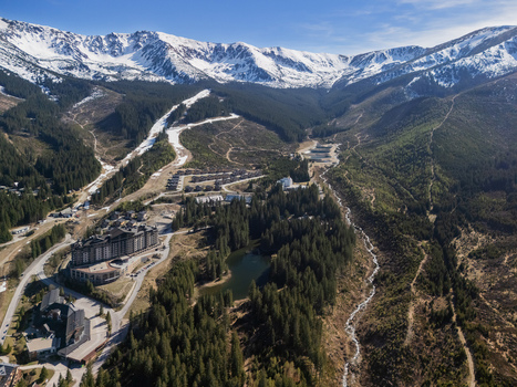 Aerial view of the Jasna ski resort nestled among pine forests and snow capped Low Tatra mountains with hotels and a small lake Demanovska Dolina Zilina Region Slovakia.