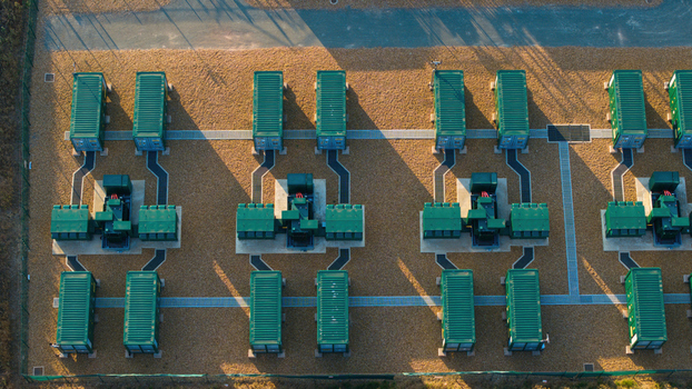 Aerial view of Battery Energy park BESS Grendon featuring rows of green battery storage containers and electrical infrastructure on a gravel site in Northampton England United Kingdom. Aerial view of Battery Energy park BESS Grendon featuring rows of green battery storage containers and electrical infrastructure on a gravel site in Northampton England United Kingdom.