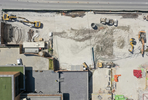 Aerial view of a busy construction site with yellow excavators heavy machinery and piles of earth near urban buildings Sariyer Istanbul Turkiye. Aerial view of a busy construction site with yellow excavators heavy machinery and piles of earth near urban buildings Sariyer Istanbul Turkiye.