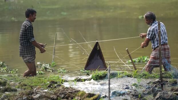 View of two fishermen using a traditional net in a river Bangladesh. View of two fishermen using a traditional net in a river Bangladesh.