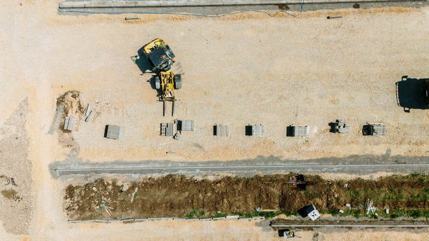 Aerial view of a yellow forklift moving materials at a construction site with stacks of bricks on gravel ground Pancevo Vojvodina Serbia.