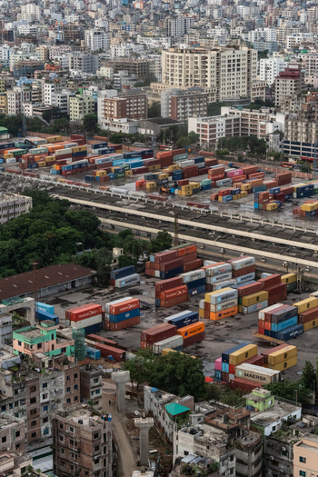 Dhaka Bangladesh 30 June 2025 Aerial view of a busy container terminal filled with colorful shipping containers situated amidst the dense urban landscape of Dhaka.