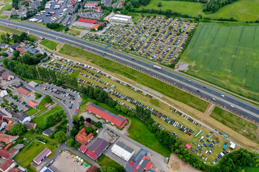 Geiselwind Germany 20 June 2025 Aerial view of the Heroes Festival Geiselwind parking lots and camping area next to the Autobahn highway surrounded by green fields.