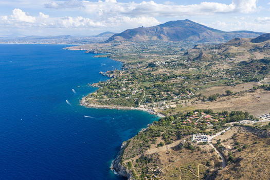 Aerial view of Riserva Naturale Orientata dello Zingaro with rugged coastal cliffs turquoise Mediterranean waters and Mediterranean scrubland in San Vito Lo Capo Sicilia Italy. Aerial view of Riserva Naturale Orientata dello Zingaro with rugged coastal cliffs turquoise Mediterranean waters and Mediterranean scrubland in San Vito Lo Capo Sicilia Italy.