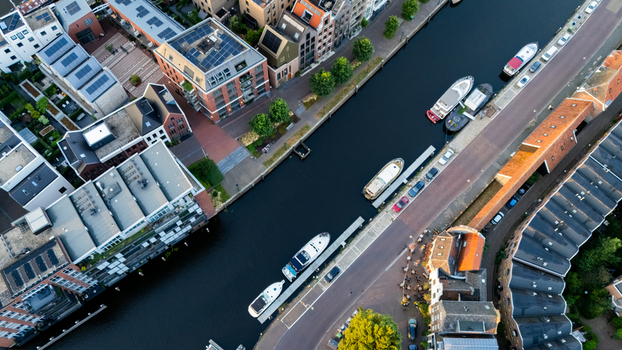 Aerial view of a canal lined with moored boats and modern residential buildings with rooftops in Zwolle Overijssel Netherlands.