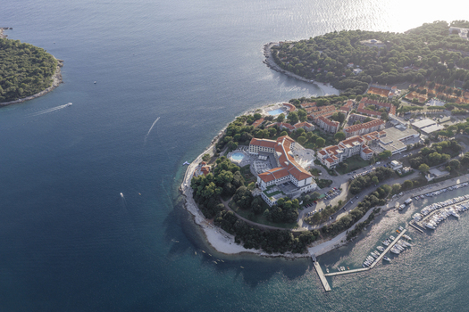 Aerial view of a coastal resort complex with swimming pools and a marina filled with boats situated on a peninsula in Pjescana Uvala Pula Istarska zupanija Croatia.