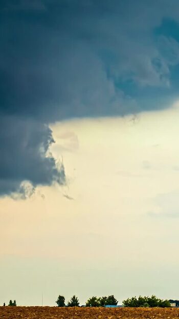 View of dramatic storm clouds over a field in Latvia. View of dramatic storm clouds over a field in Latvia.