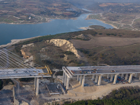 Aerial view of a bridge under construction with concrete pillars and steel cables spanning over a landscape with a reservoir and hills in Istanbul Istanbul Turkiye.