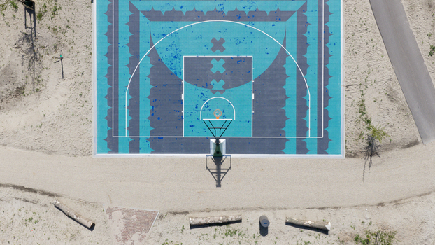 Aerial view of the colorful basketball court at Tagorepark featuring geometric patterns and a hoop surrounded by sandy terrain and paths in Amsterdam North Holland Netherlands.