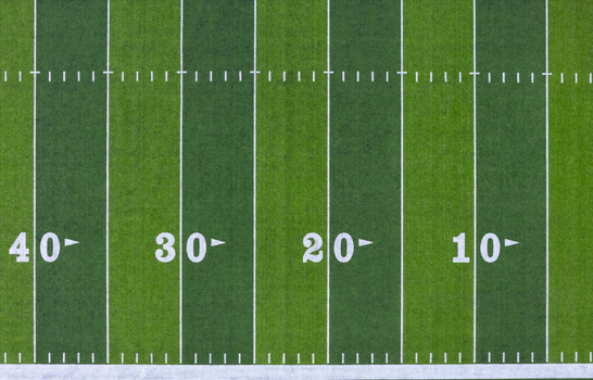 Aerial view of a football field with white yard line markers on green turf in Kalamazoo Michigan United States.