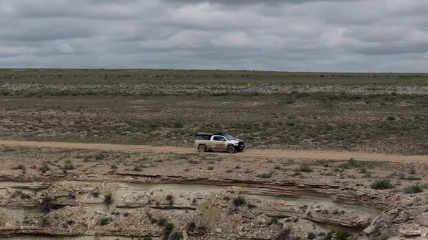 Aerial view of an off road vehicle driving through Bozjyra Kazakhstan. Aerial view of an off road vehicle driving through Bozjyra Kazakhstan.
