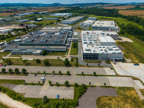 Aerial view of a modern industrial park with large warehouse buildings flat roofs parking lots and surrounding green fields in Zebrak Central Bohemian Region Czechia. Aerial view of a modern industrial park with large warehouse buildings flat roofs parking lots and surrounding green fields in Zebrak Central Bohemian Region Czechia.