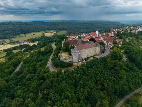 Aerial view of Schloss Waldenburg surrounded by historic town rooftops winding roads and lush green forests in Waldenburg Sachsen Germany. Aerial view of Schloss Waldenburg surrounded by historic town rooftops winding roads and lush green forests in Waldenburg Sachsen Germany.