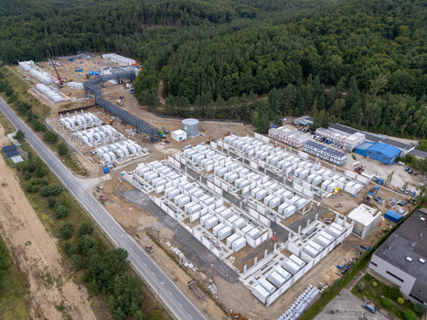 Aerial view of the Zarnowiec Pumped Storage Power Station construction site with white industrial containers and machinery near a forest in Wejherowo County Pomeranian Voivodeship Poland.