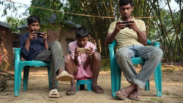 View of young men using smartphones in Bogura Bangladesh. View of young men using smartphones in Bogura Bangladesh.