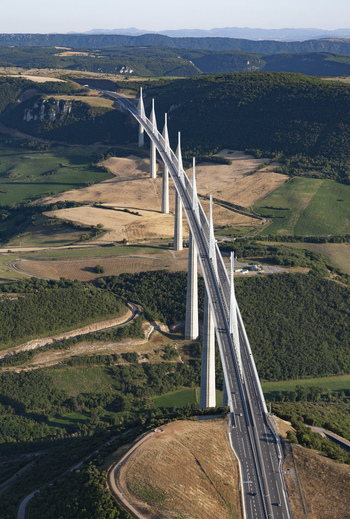 Aerial view of the Millau Viaduct slicing through the sun drenched landscape a modern marvel against the rustic charm of the French countryside Millau France. Aerial view of the Millau Viaduct slicing through the sun drenched landscape a modern marvel against the rustic charm of the French countryside Millau France.