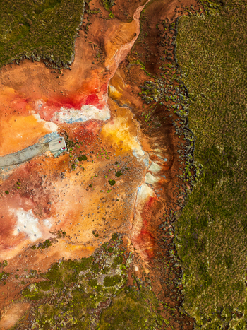 Aerial view of vibrant geothermal landscape with colorful mineral deposits red and orange soil rocky terrain and patches of green moss in Iceland. Aerial view of vibrant geothermal landscape with colorful mineral deposits red and orange soil rocky terrain and patches of green moss in Iceland.