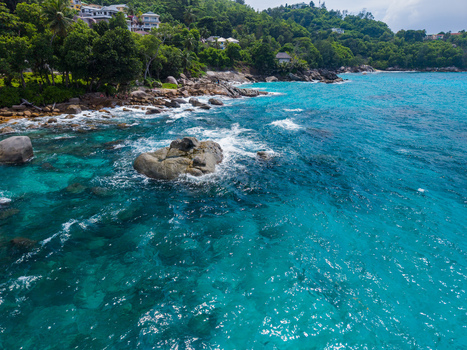 Aerial view of rugged coastline where turquoise waters meet verdant hills creating a stunning contrast of colors and textures Vista do Mar Mahe Island Seychelles. Aerial view of rugged coastline where turquoise waters meet verdant hills creating a stunning contrast of colors and textures Vista do Mar Mahe Island Seychelles.