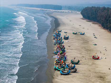 Cox s Bazar Bangladesh 10 March 2026 Aerial view of colorful moon boats lined up on the sandy shore with crashing waves and a dense casuarina forest. Cox s Bazar Bangladesh 10 March 2026 Aerial view of colorful moon boats lined up on the sandy shore with crashing waves and a dense casuarina forest.
