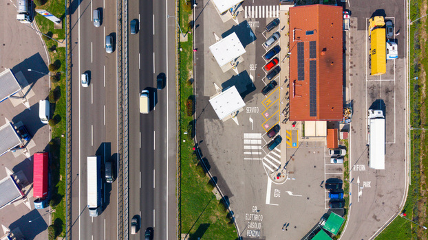 Aerial view of a gas station with parked cars trucks and fuel pumps located along a highway in San Giuliano Milanese Lombardy Italy.