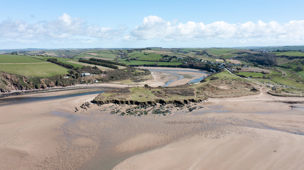 Aerial view of Bantham Beach featuring the sandy estuary and rolling green hills under a bright sky Kingsbridge Devon United Kingdom. Aerial view of Bantham Beach featuring the sandy estuary and rolling green hills under a bright sky Kingsbridge Devon United Kingdom.