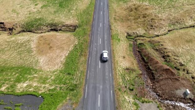 Aerial view of a car driving on a road in Hvalfjordur Iceland. Aerial view of a car driving on a road in Hvalfjordur Iceland.
