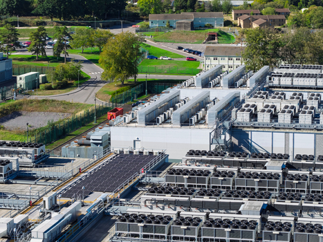 Aerial view of a data center with rows of cooling units and ventilation systems on the roof in the United Kingdom.
