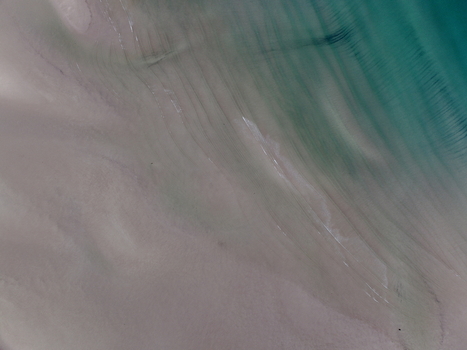 Aerial view of Gruinard Bay showing the sandy beach textures and shallow turquoise water ripples in Gruinard Scotland United Kingdom. Aerial view of Gruinard Bay showing the sandy beach textures and shallow turquoise water ripples in Gruinard Scotland United Kingdom.