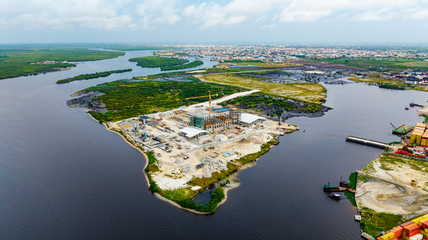 Aerial view of the construction site at Satellite Town featuring industrial buildings a crane and surrounding water in Lagos Lagos Nigeria.