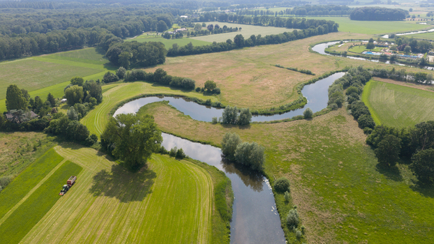 Aerial view of the winding Berkel river flowing through lush green meadows and agricultural fields in the countryside of Almen Gelderland Netherlands. Aerial view of the winding Berkel river flowing through lush green meadows and agricultural fields in the countryside of Almen Gelderland Netherlands.
