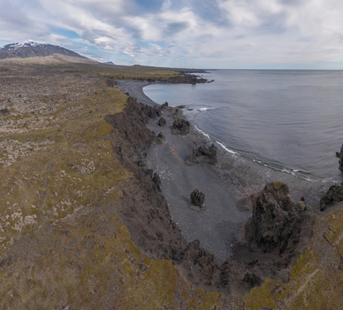 Aerial view of Djupalonssandur beach featuring dramatic black volcanic sand rugged rock formations and the Atlantic coastline under a cloudy sky in Iceland. Aerial view of Djupalonssandur beach featuring dramatic black volcanic sand rugged rock formations and the Atlantic coastline under a cloudy sky in Iceland.