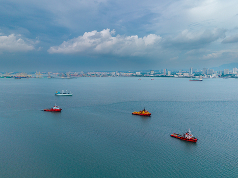 George Town Malaysia 22 September 2026 Aerial view of ships navigating the calm waters of the Penang Strait with the city skyline visible in the background. George Town Malaysia 22 September 2026 Aerial view of ships navigating the calm waters of the Penang Strait with the city skyline visible in the background.