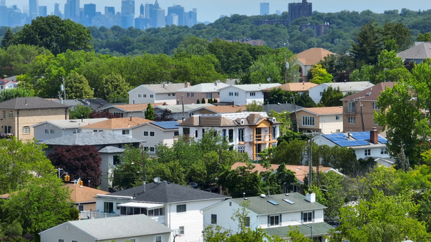 Aerial view of Staten Island Greenbelt surrounded by residential houses lush green trees and the New York City skyline in the distance New York New York United States.