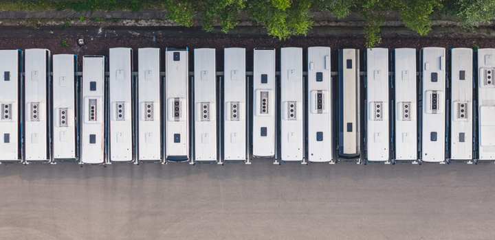 Aerial view of a fleet of modern public transport buses parked in parallel at a depot showcasing geometric urban mobility in Loriol sur Drome Auvergne Rhone Alpes France.