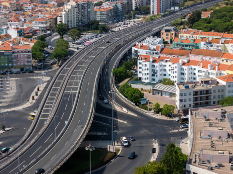 Aerial view of the highway interchange in Alges featuring multi lane roads surrounding urban residential buildings and light traffic in Alges Lisbon Portugal.