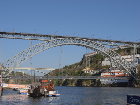 View of the iconic Dom Luis I Bridge spanning the Douro River with historic buildings on the hillside in Porto Porto District Portugal. View of the iconic Dom Luis I Bridge spanning the Douro River with historic buildings on the hillside in Porto Porto District Portugal.