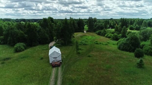 Aerial view of a house being transported on a truck in Latvia.