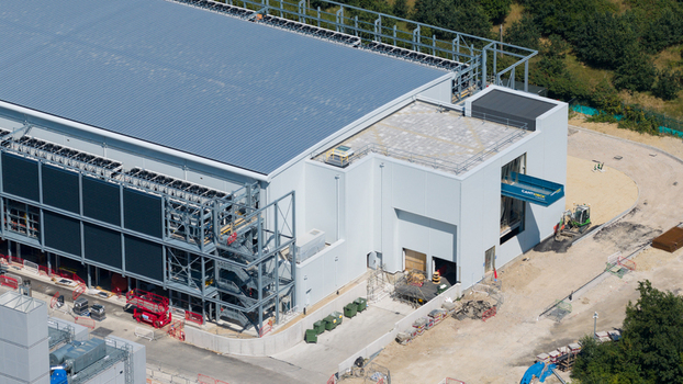 Aerial view of the Kao Data facility featuring modern industrial architecture with cooling units and construction activity in Harlow England United Kingdom. Aerial view of the Kao Data facility featuring modern industrial architecture with cooling units and construction activity in Harlow England United Kingdom.