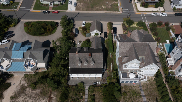 Aerial view of coastal residential houses with shingle roofs wooden decks and sandy dunes in Mantoloking New Jersey United States.