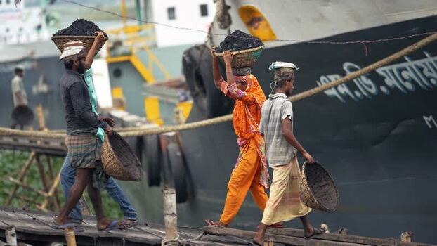View of workers carrying coal baskets in Aminbazar Bangladesh. View of workers carrying coal baskets in Aminbazar Bangladesh.