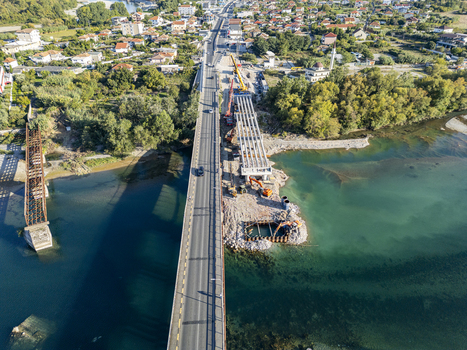 Aerial view of the Ura e Bahcallekut bridge construction site over the Drin river with cranes and machinery visible near the town of Bahcallek Shkoder County Albania. Aerial view of the Ura e Bahcallekut bridge construction site over the Drin river with cranes and machinery visible near the town of Bahcallek Shkoder County Albania.