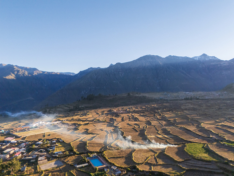 Aerial view of terraced agricultural fields small fires and the town of Cabanaconde set against the Andes mountains in Cabanaconde Arequipa Peru. Aerial view of terraced agricultural fields small fires and the town of Cabanaconde set against the Andes mountains in Cabanaconde Arequipa Peru.