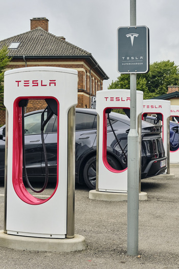 Esbjerg Denmark 25 July 2026 View of Tesla Supercharger station with electric vehicles charging in a parking area.